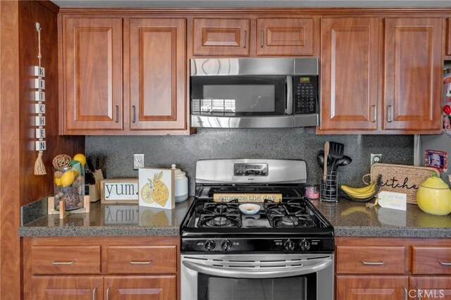 13520 Preciado Ave, Chino, CA 91710 - kitchen featuring appliances with stainless steel finishes, brown cabinetry, and dark stone counters