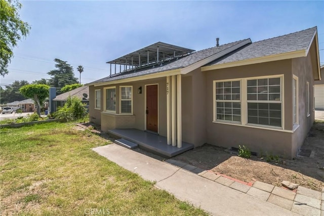 717 La Porte Ave, San Bernardino, CA 92405 - view of front of property featuring a front yard, stucco siding, and a shingled roof