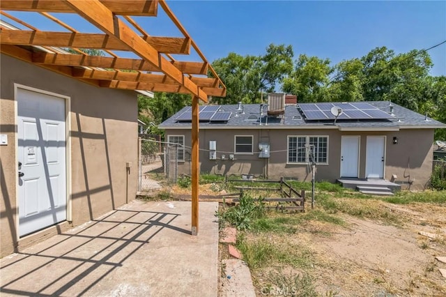 717 La Porte Ave, San Bernardino, CA 92405 - back of house with roof mounted solar panels, a gate, stucco siding, and roof with shingles