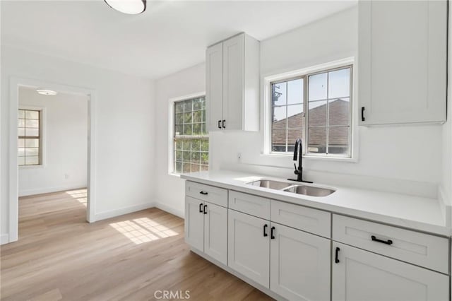 717 La Porte Ave, San Bernardino, CA 92405 - kitchen featuring light wood finished floors, light countertops, and white cabinetry
