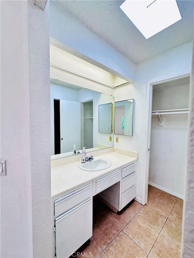 343 Park Shadow Ct, Baldwin Park, CA 91706 - bathroom with vanity, tile patterned flooring, a spacious closet, and a skylight