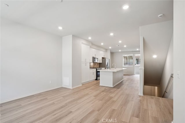 1549 Stratus Dr, Pomona, CA 91768 - kitchen featuring stainless steel appliances, an island with sink, light wood-type flooring, white cabinets, and recessed lighting