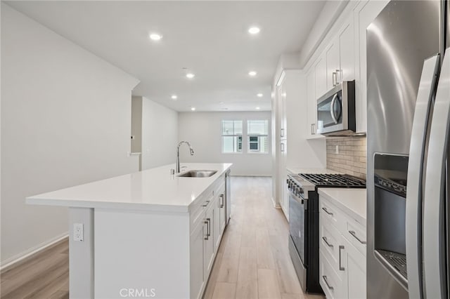 1549 Stratus Dr, Pomona, CA 91768 - kitchen featuring appliances with stainless steel finishes, light wood-style flooring, recessed lighting, a kitchen island with sink, and light countertops
