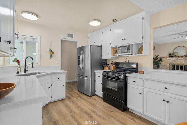 3542 Lillian St, Riverside, CA 92504 - kitchen with appliances with stainless steel finishes, white cabinetry, light countertops, light wood-style floors, and a textured ceiling