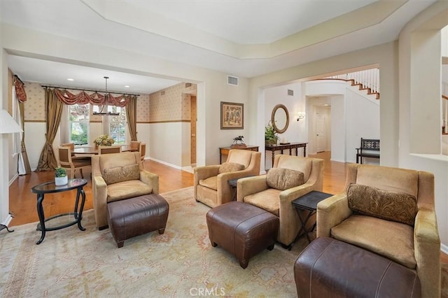 26860 Chaucer Pl, Stevenson Ranch, CA 91381 - living area with wallpapered walls, wood finished floors, a chandelier, arched walkways, and stairs