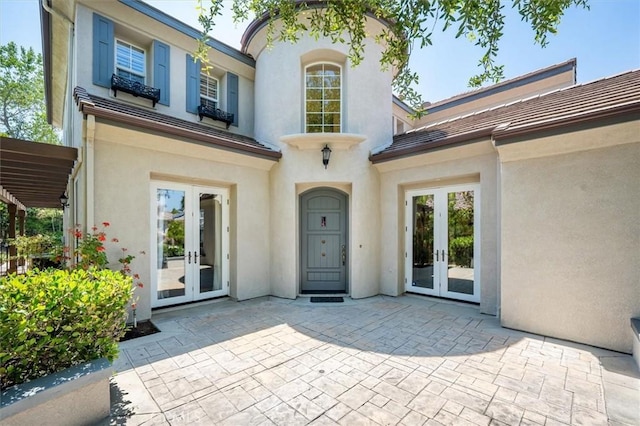 26860 Chaucer Pl, Stevenson Ranch, CA 91381 - doorway to property with french doors, stucco siding, and a patio area