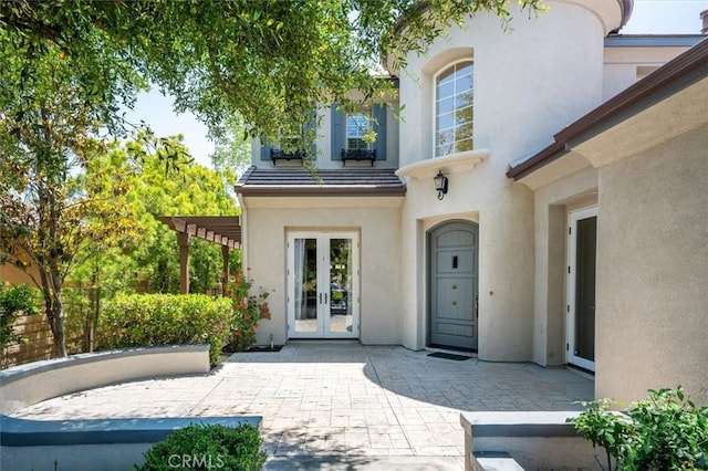 26860 Chaucer Pl, Stevenson Ranch, CA 91381 - entrance to property featuring french doors, stucco siding, a pergola, and a patio area