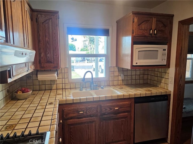 20450 Bassett St, Winnetka, CA 91306 - kitchen featuring stainless steel dishwasher, white microwave, tasteful backsplash, stovetop, and tile counters