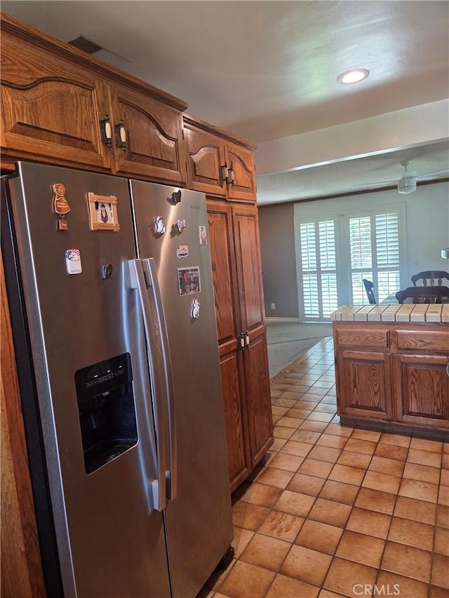 20450 Bassett St, Winnetka, CA 91306 - kitchen with stainless steel refrigerator with ice dispenser, brown cabinetry, tile counters, recessed lighting, and open floor plan