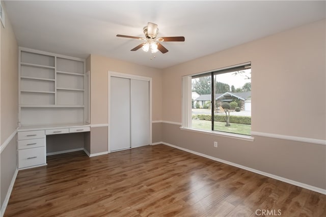 10025 Lubao Ave, Chatsworth, CA 91311 - unfurnished bedroom with wood finished floors, a closet, built in desk, and ceiling fan