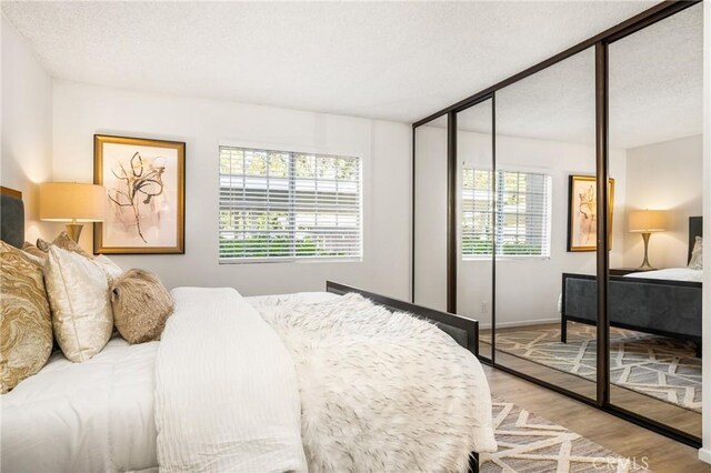 38 Woodleaf, Irvine, CA 92614 - bedroom with wood finished floors, a closet, and a textured ceiling