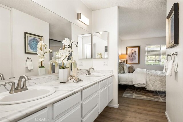 38 Woodleaf, Irvine, CA 92614 - full bath with double vanity, wood finished floors, ensuite bathroom, and a textured ceiling