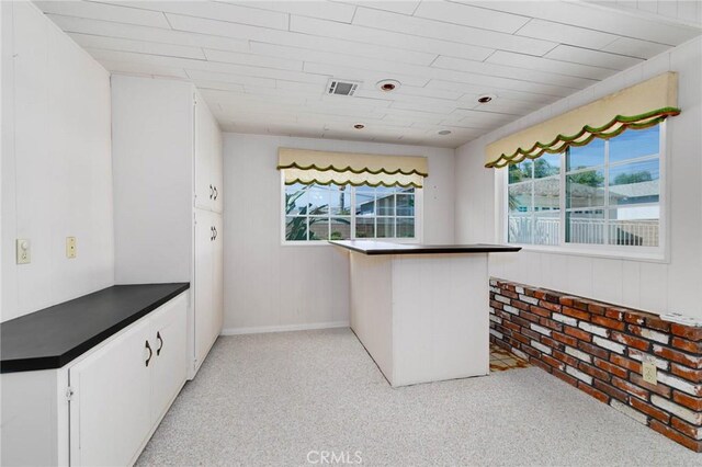 1333 E Tudor St, Covina, CA 91724 - kitchen with dark countertops, healthy amount of natural light, and white cabinetry