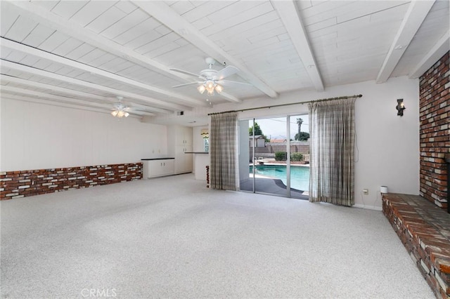 1333 E Tudor St, Covina, CA 91724 - unfurnished living room with a ceiling fan, carpet, beam ceiling, and brick wall