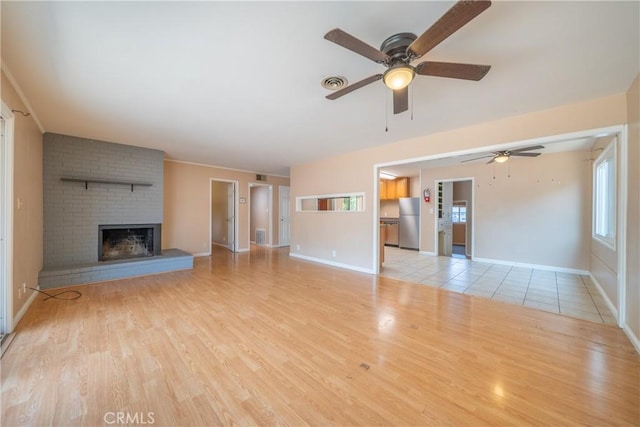 1577 Hawthorne Ave, Chico, CA 95926 - unfurnished living room featuring a ceiling fan, light wood-style flooring, and a brick fireplace