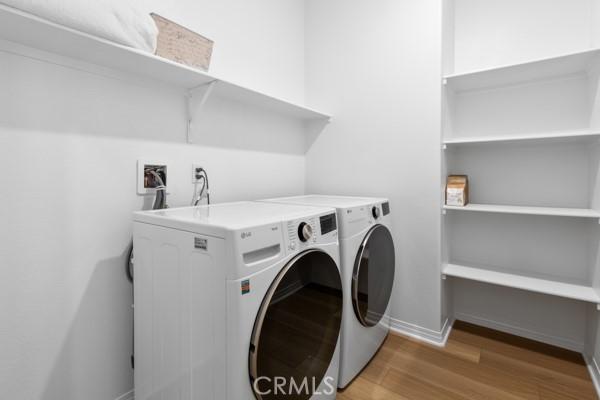 15940 Lasselle St Unit 1, Moreno Valley, CA 92551 - washroom with washing machine and clothes dryer and light wood-type flooring