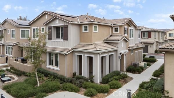 15940 Lasselle St Unit 1, Moreno Valley, CA 92551 - view of front of house featuring a tiled roof, roof mounted solar panels, stucco siding, and a residential view