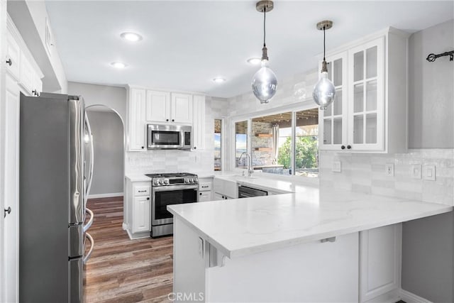 21751 Lanar, Mission Viejo, CA 92692 - kitchen with stainless steel appliances, a peninsula, wood finished floors, white cabinets, and recessed lighting