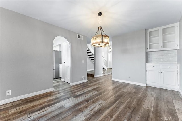 21751 Lanar, Mission Viejo, CA 92692 - unfurnished dining area with arched walkways, dark wood finished floors, stairway, and a chandelier