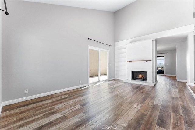 21751 Lanar, Mission Viejo, CA 92692 - unfurnished living room with a towering ceiling, wood finished floors, a brick fireplace, and built in features