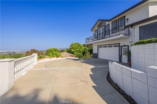 14757 Rockhill Dr, Hacienda Heights, CA 91745 - view of side of property with a balcony, stucco siding, concrete driveway, and an attached garage