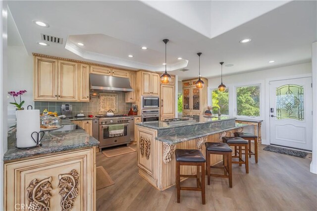 14757 Rockhill Dr, Hacienda Heights, CA 91745 - kitchen featuring exhaust hood, appliances with stainless steel finishes, light wood-type flooring, a kitchen breakfast bar, and tasteful backsplash