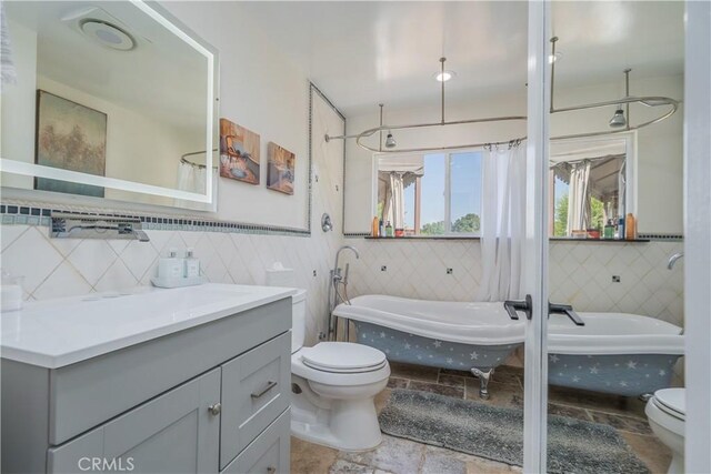14757 Rockhill Dr, Hacienda Heights, CA 91745 - bathroom with a tub to relax in, vanity, tile walls, and stone finish floors