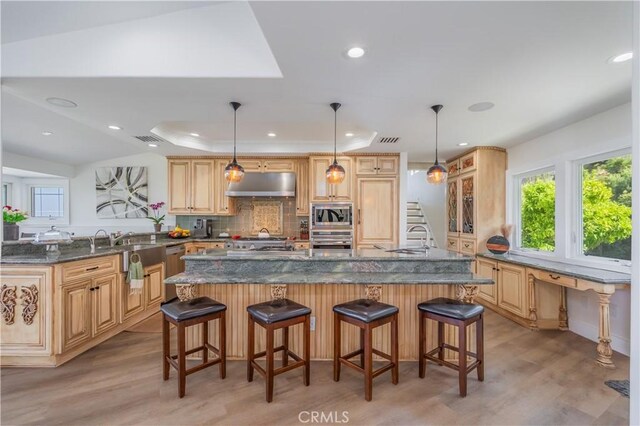 14757 Rockhill Dr, Hacienda Heights, CA 91745 - kitchen featuring stainless steel appliances, under cabinet range hood, light wood finished floors, recessed lighting, and a kitchen bar