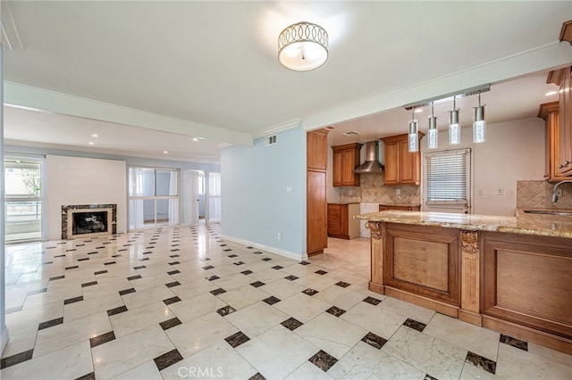 20129 Halsted St, Chatsworth, CA 91311 - kitchen with wall chimney exhaust hood, brown cabinets, light stone counters, decorative backsplash, and ornamental molding