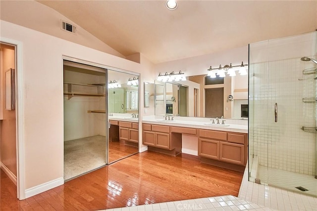 26821 Moore Oaks Rd, Laguna Hills, CA 92653 - bathroom with hardwood / wood-style floors, double vanity, a shower stall, lofted ceiling, and a walk in closet