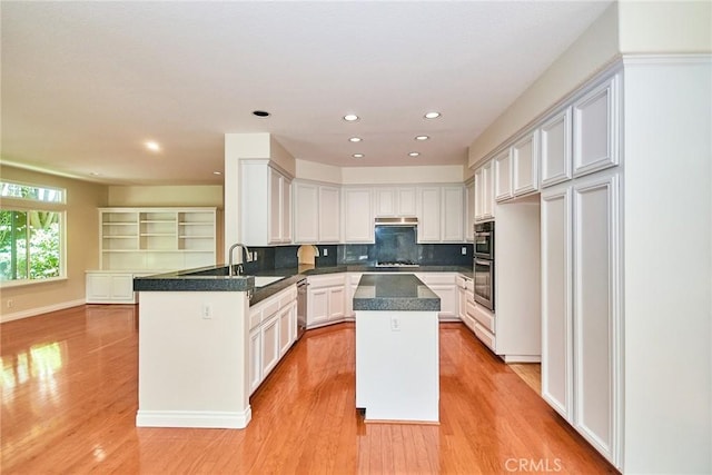 26821 Moore Oaks Rd, Laguna Hills, CA 92653 - kitchen with a peninsula, light wood finished floors, under cabinet range hood, backsplash, and recessed lighting