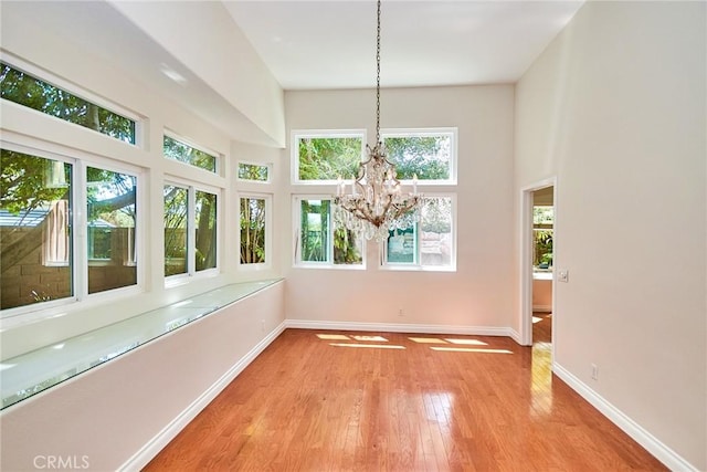 26821 Moore Oaks Rd, Laguna Hills, CA 92653 - unfurnished dining area featuring a towering ceiling, light wood finished floors, and a chandelier