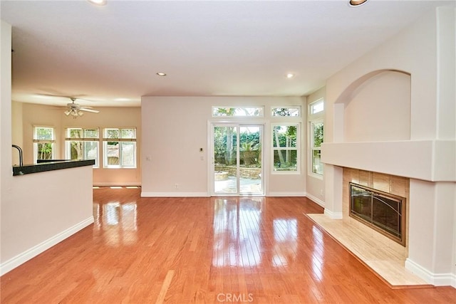 26821 Moore Oaks Rd, Laguna Hills, CA 92653 - unfurnished living room with plenty of natural light, a fireplace, light wood-style floors, a ceiling fan, and recessed lighting