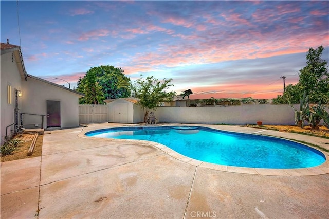 10028 Judy Ct, Riverside, CA 92503 - pool at dusk featuring a storage unit, a patio area, and a fenced backyard