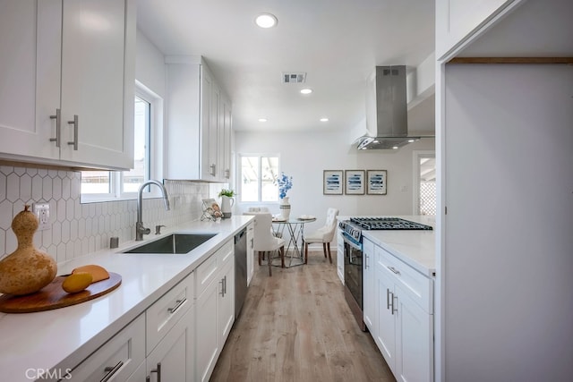 10028 Judy Ct, Riverside, CA 92503 - kitchen with stainless steel range with gas stovetop, island exhaust hood, white cabinets, light countertops, and recessed lighting