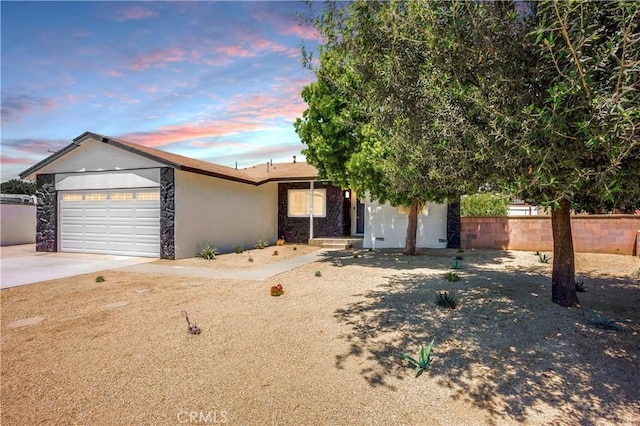 10028 Judy Ct, Riverside, CA 92503 - view of front of property with stone siding, driveway, a garage, and stucco siding