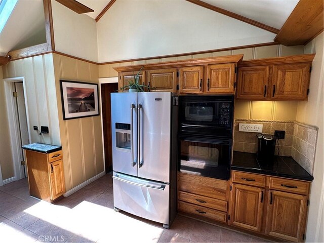 41379 Rainbow Ln, Forest Falls, CA 92339 - kitchen with black appliances, vaulted ceiling, dark countertops, light tile patterned floors, and backsplash