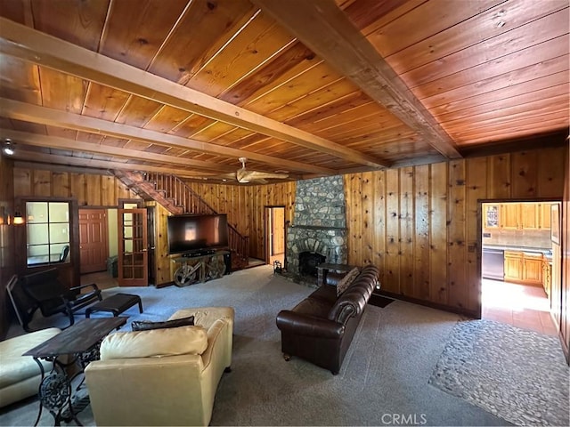 41379 Rainbow Ln, Forest Falls, CA 92339 - carpeted living area with a wood ceiling with exposed beams, wooden walls, stairs, and a stone fireplace