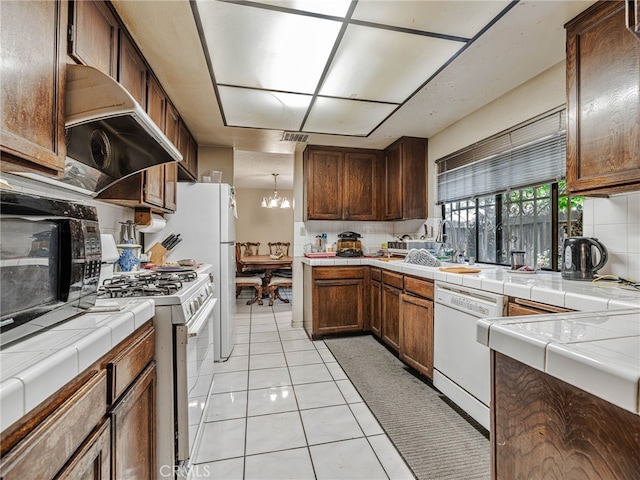 7800 Winnetka Ave, Winnetka, CA 91306 - kitchen with white appliances, tile counters, extractor fan, tasteful backsplash, and a chandelier