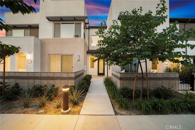 3540 E Peckham Paseo Unit 5, Ontario, CA 91761 - view of front of property with stucco siding and a fenced front yard