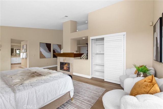 21620 Brisbane Way, Yorba Linda, CA 92887 - bedroom featuring a closet, wood finished floors, a tile fireplace, a towering ceiling, and connected bathroom