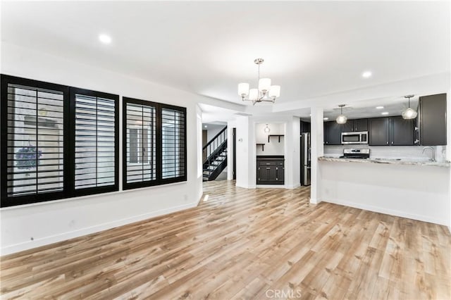 5401 Zelzah Ave Unit 114, Encino, CA 91316 - unfurnished living room with a chandelier, light wood-style floors, recessed lighting, and stairs