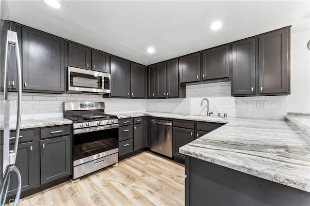 5401 Zelzah Ave Unit 114, Encino, CA 91316 - kitchen with stainless steel appliances, light stone counters, backsplash, and recessed lighting