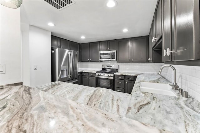 5401 Zelzah Ave Unit 114, Encino, CA 91316 - kitchen featuring appliances with stainless steel finishes, light stone countertops, tasteful backsplash, and recessed lighting