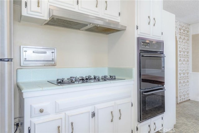 5361 Ludlow Ave, Garden Grove, CA 92845 - kitchen with light countertops, white cabinetry, gas cooktop, under cabinet range hood, and freestanding refrigerator