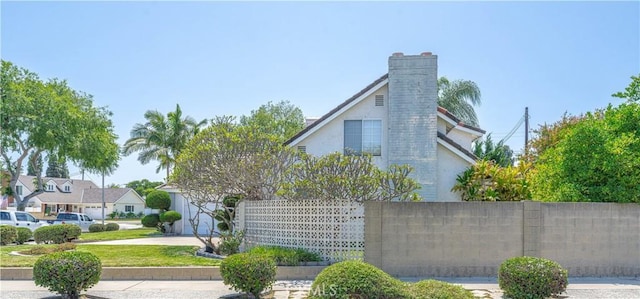 5361 Ludlow Ave, Garden Grove, CA 92845 - view of home's exterior with stucco siding, a chimney, and concrete driveway