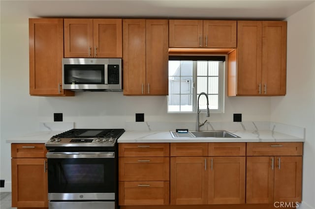 4820 W 142nd St, Hawthorne, CA 90250 - kitchen featuring stainless steel appliances, brown cabinetry, and light stone countertops