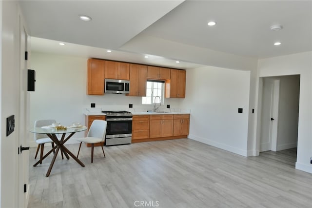 4820 W 142nd St, Hawthorne, CA 90250 - kitchen with appliances with stainless steel finishes, recessed lighting, light countertops, light wood-type flooring, and brown cabinetry