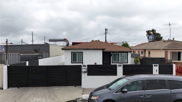 4820 W 142nd St, Hawthorne, CA 90250 - view of front of house featuring stucco siding, a fenced front yard, a gate, and roof with shingles