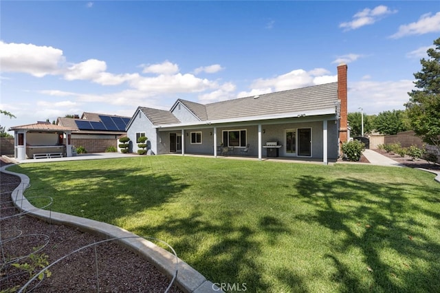 43419 37th St W, Lancaster, CA 93536 - rear view of house featuring a patio, stucco siding, a tile roof, a chimney, and solar panels